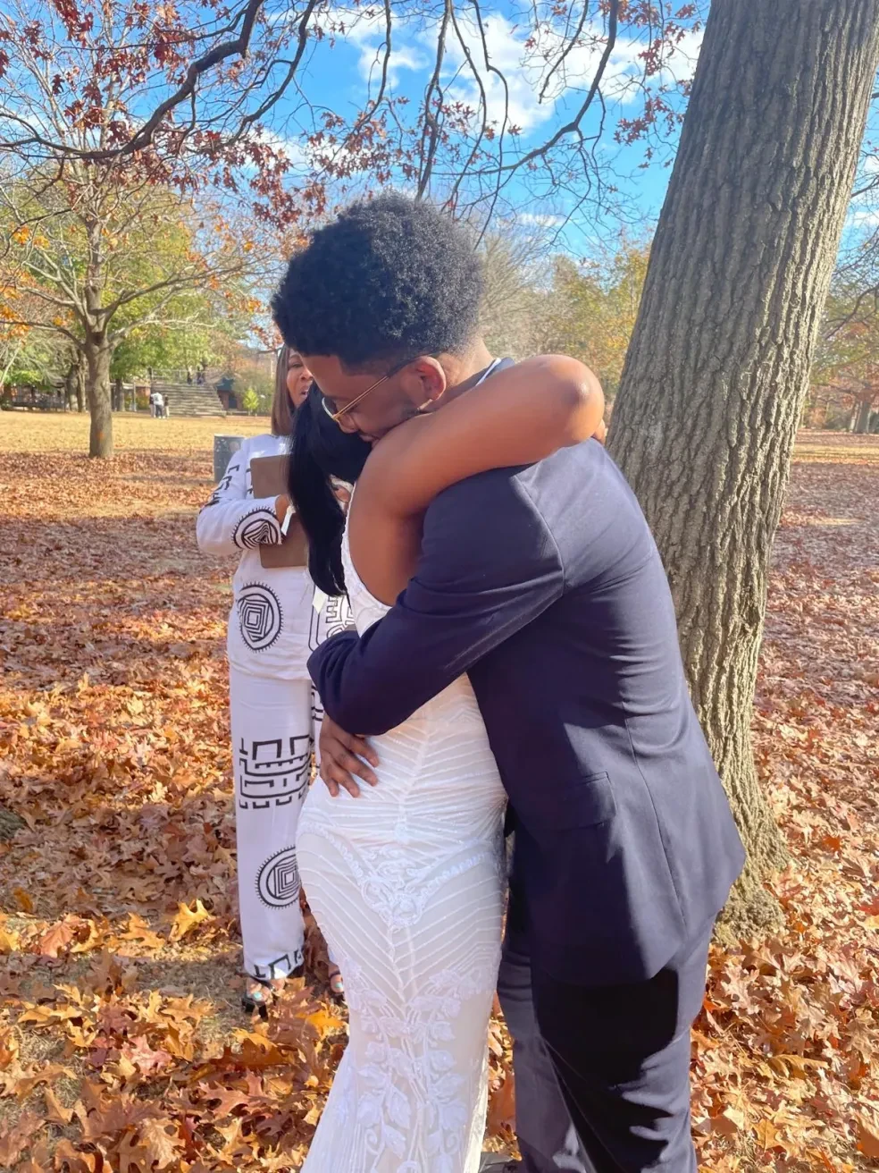 Couple embracing during autumn outdoor ceremony